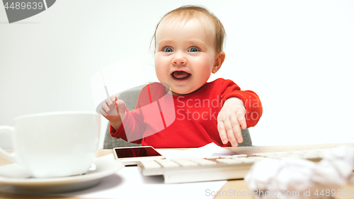 Image of Happy child baby girl toddler sitting with keyboard of computer isolated on a white background