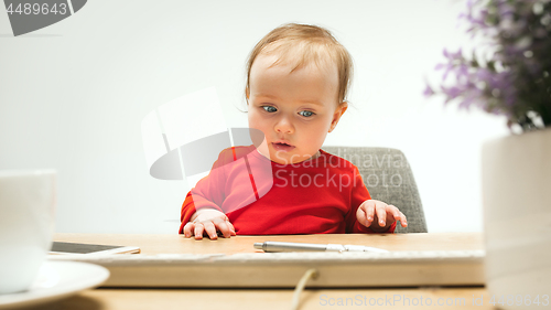 Image of Happy child baby girl toddler sitting with keyboard of computer isolated on a white background