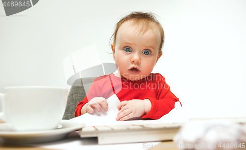 Image of Happy child baby girl toddler sitting with keyboard of computer isolated on a white background
