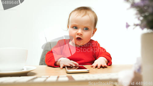 Image of Happy child baby girl toddler sitting with keyboard of computer isolated on a white background