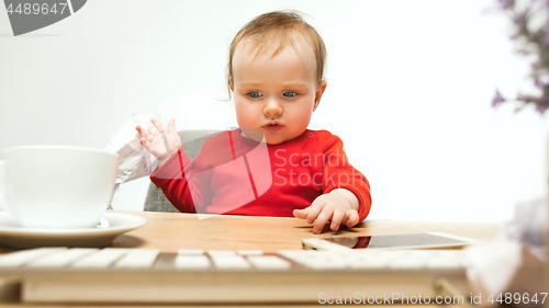 Image of Happy child baby girl toddler sitting with keyboard of computer isolated on a white background