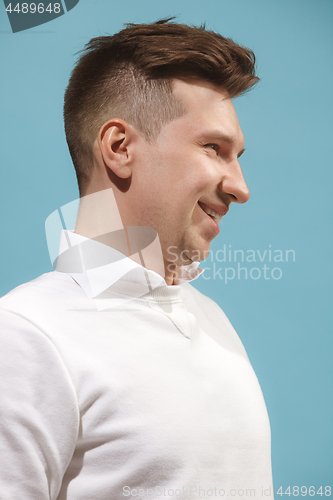 Image of The happy business man standing and smiling against studio background.