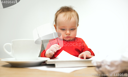 Image of Happy child baby girl toddler sitting with keyboard of computer isolated on a white background