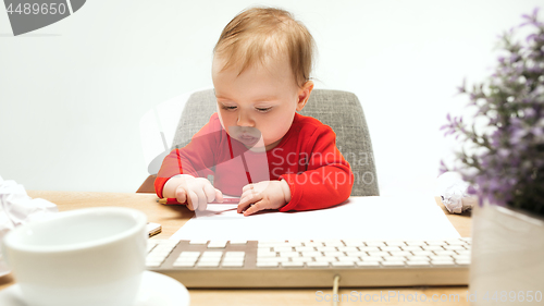 Image of Happy child baby girl toddler sitting with keyboard of computer isolated on a white background