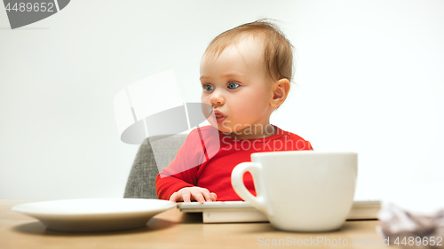 Image of Happy child baby girl toddler sitting with keyboard of computer isolated on a white background