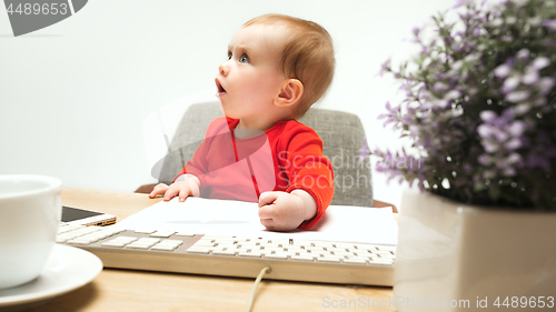 Image of Happy child baby girl toddler sitting with keyboard of computer isolated on a white background