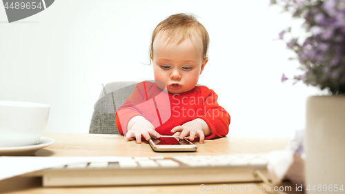 Image of Happy child baby girl toddler sitting with keyboard of computer isolated on a white background