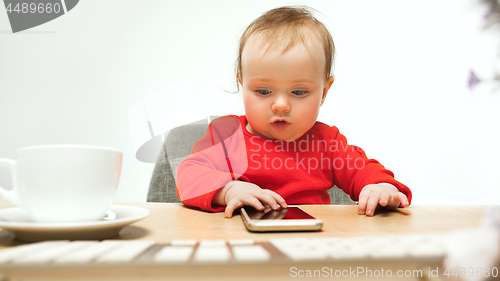 Image of Happy child baby girl toddler sitting with keyboard of computer isolated on a white background