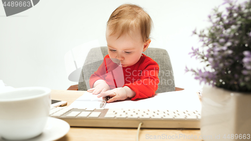 Image of Happy child baby girl toddler sitting with keyboard of computer isolated on a white background