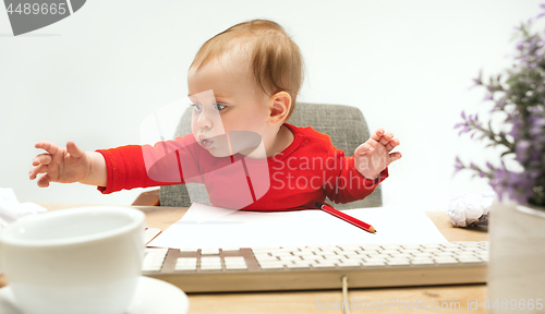 Image of Happy child baby girl toddler sitting with keyboard of computer isolated on a white background