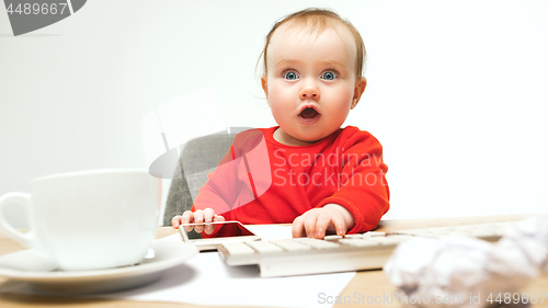 Image of Happy child baby girl toddler sitting with keyboard of computer isolated on a white background