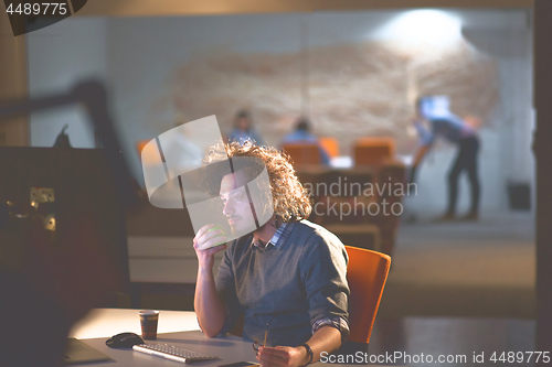 Image of man working on computer in dark office