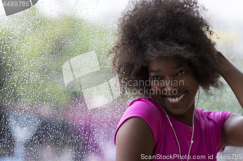 Image of portrait of young afro american woman in gym while listening mus