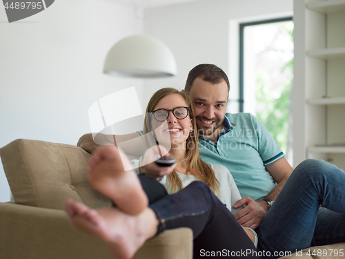 Image of Young couple on the sofa watching television