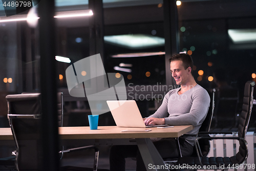 Image of man working on laptop in dark office