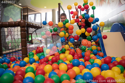 Image of Young mom with her kids in a children\'s playroom