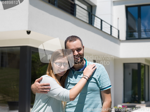 Image of couple hugging in front of  new luxury home