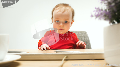 Image of Happy child baby girl toddler sitting with keyboard of computer isolated on a white background