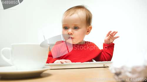 Image of Happy child baby girl toddler sitting with keyboard of computer isolated on a white background