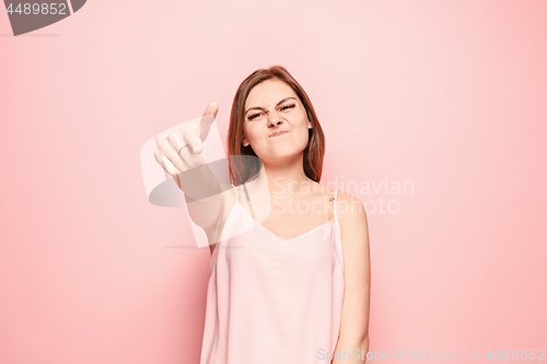 Image of The overbearing woman point you and want you, half length closeup portrait on pink background.