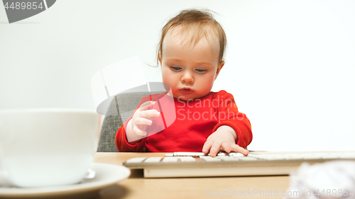 Image of Happy child baby girl toddler sitting with keyboard of computer isolated on a white background