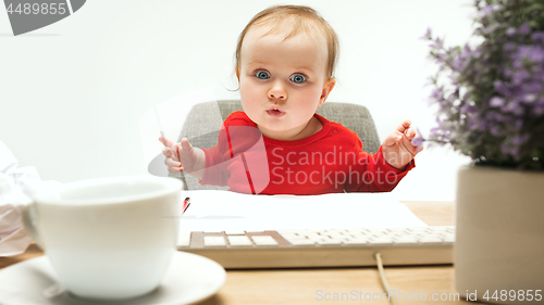 Image of Happy child baby girl toddler sitting with keyboard of computer isolated on a white background