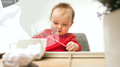 Image of Happy child baby girl toddler sitting with keyboard of computer isolated on a white background