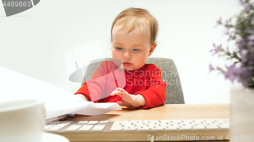 Image of Happy child baby girl toddler sitting with keyboard of computer isolated on a white background