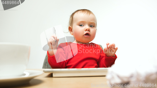 Image of Happy child baby girl toddler sitting with keyboard of computer isolated on a white background
