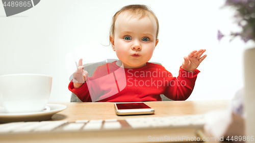 Image of Happy child baby girl toddler sitting with keyboard of computer isolated on a white background