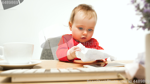 Image of Happy child baby girl toddler sitting with keyboard of computer isolated on a white background