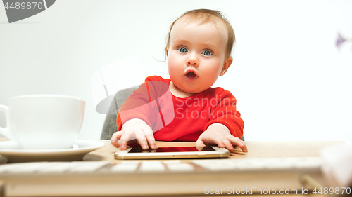 Image of Happy child baby girl toddler sitting with keyboard of computer isolated on a white background