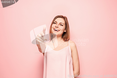 Image of The happy woman point you and want you, half length closeup portrait on pink background.