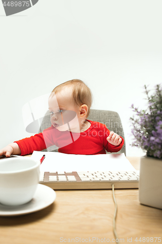 Image of Happy child baby girl toddler sitting with keyboard of computer isolated on a white background