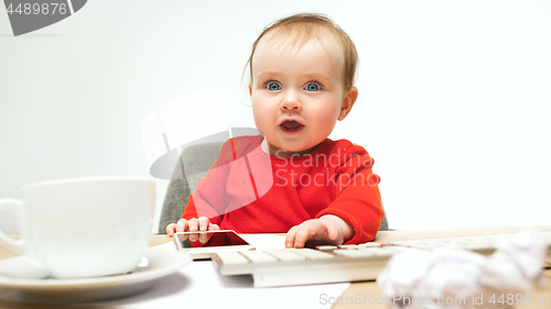 Image of Happy child baby girl toddler sitting with keyboard of computer isolated on a white background