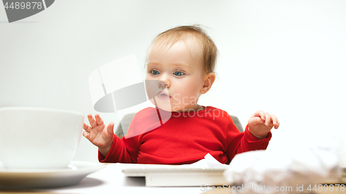 Image of Happy child baby girl toddler sitting with keyboard of computer isolated on a white background