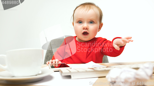 Image of Happy child baby girl toddler sitting with keyboard of computer isolated on a white background