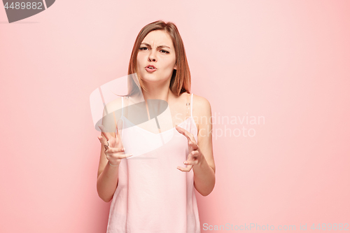 Image of Beautiful female half-length portrait isolated on pink studio backgroud. The young emotional surprised woman