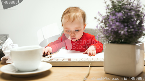 Image of Happy child baby girl toddler sitting with keyboard of computer isolated on a white background