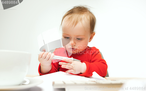 Image of Happy child baby girl toddler sitting with keyboard of computer isolated on a white background