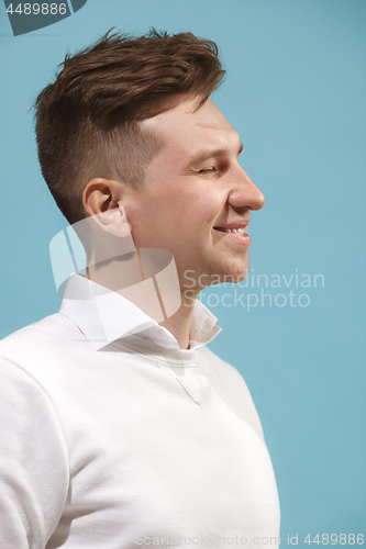 Image of The happy business man standing and smiling against studio background.