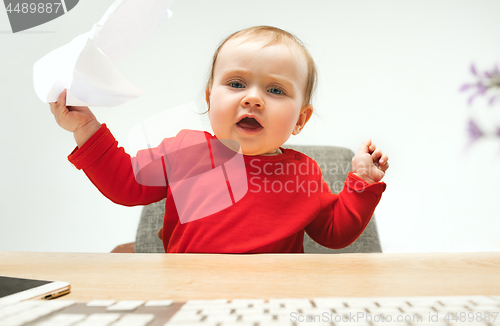 Image of Happy child baby girl toddler sitting with keyboard of computer isolated on a white background