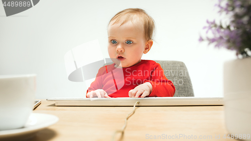 Image of Happy child baby girl toddler sitting with keyboard of computer isolated on a white background