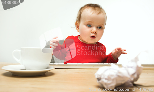 Image of Happy child baby girl toddler sitting with keyboard of computer isolated on a white background