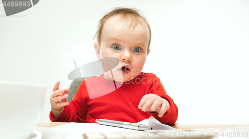 Image of Happy child baby girl toddler sitting with keyboard of computer isolated on a white background