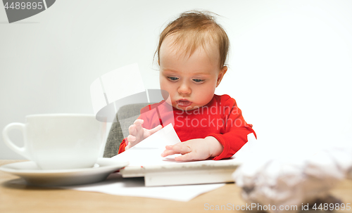 Image of Happy child baby girl toddler sitting with keyboard of computer isolated on a white background