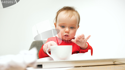 Image of Happy child baby girl toddler sitting with keyboard of computer isolated on a white background