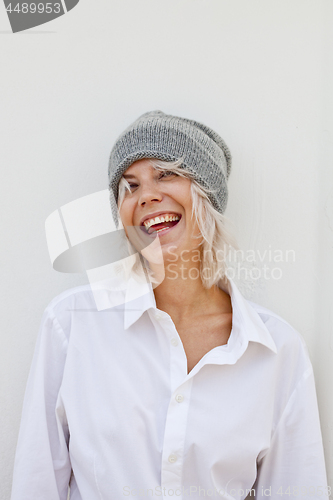 Image of Beautiful happy young woman in warm grey beanie.