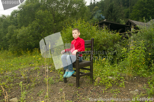 Image of Boy Sitting on Chair in the Forest