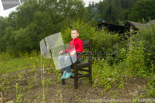 Image of Boy Sitting on Chair in the Forest